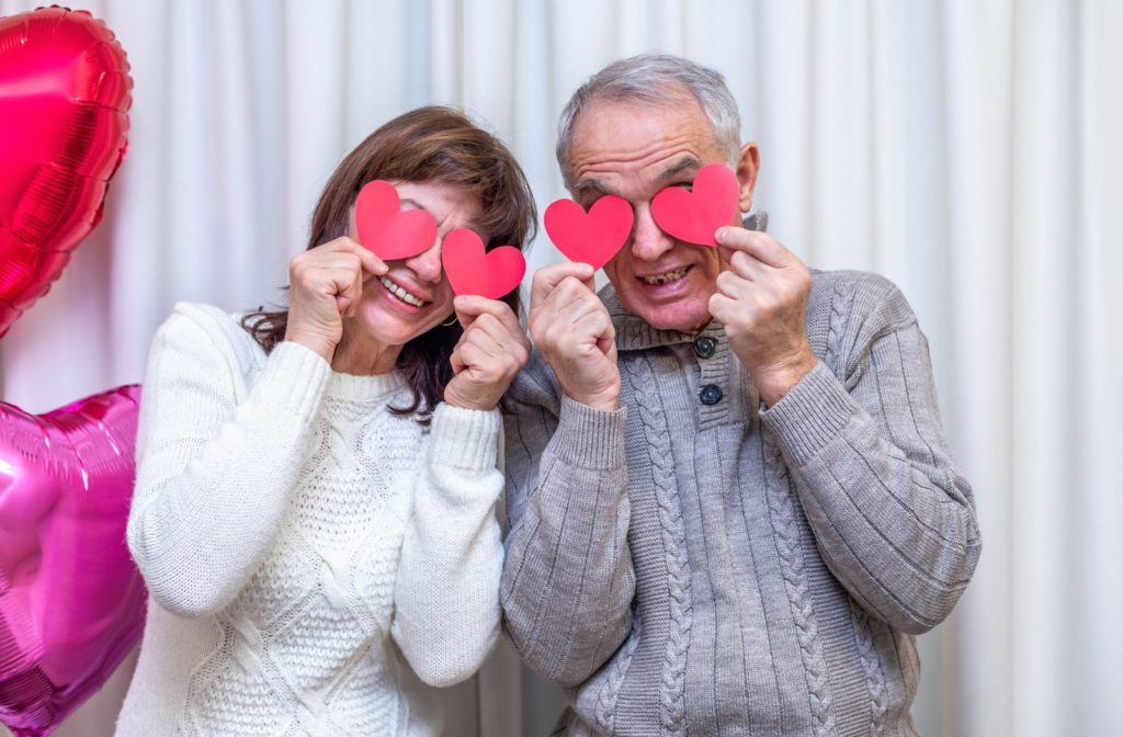 Alt text: Assisted living residents showcasing their home-made heart-shaped Valentine's Day decorations.