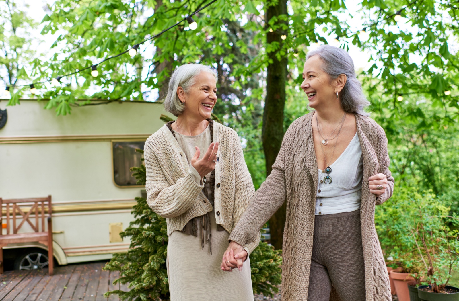 A happy retired couple hold hands, enjoying getting to spend more time with each other while outdoors on a vacation trip.
